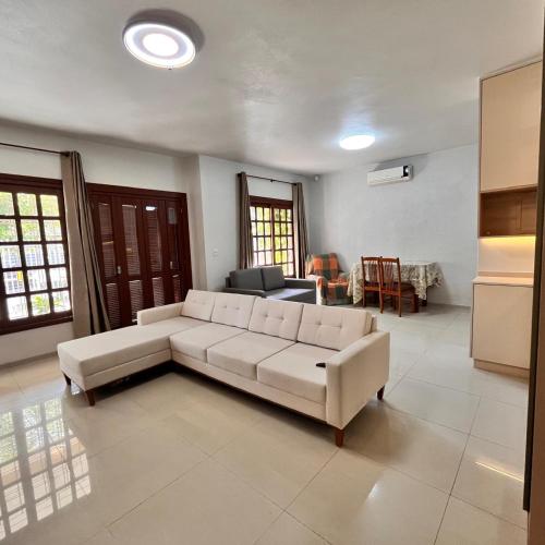 a living room with a white couch and a table at Casa do vivi in Tramandaí