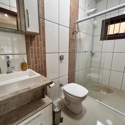 a bathroom with a toilet and a sink and a shower at Casa do vivi in Tramandaí