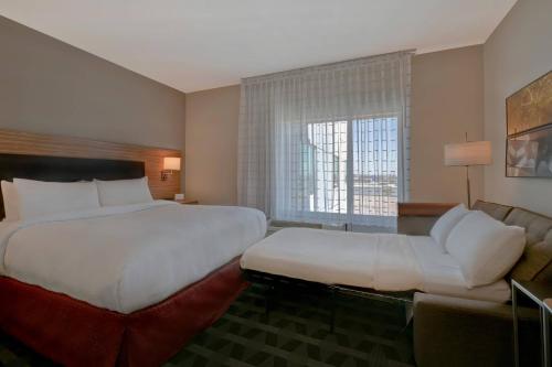 a hotel room with a large bed and a couch at TownePlace Suites by Marriott El Paso East/I-10 in El Paso