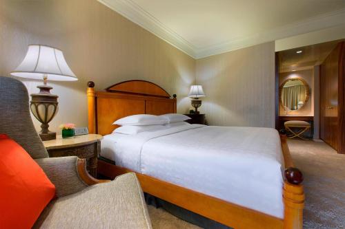 a bedroom with a large bed and a chair at Sheraton Towers Singapore Hotel in Singapore