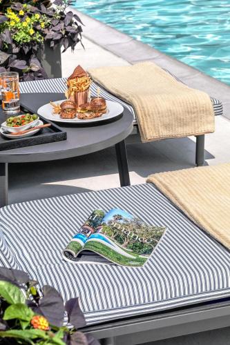 a table with a plate of food next to a pool at Le Méridien St. Louis Clayton in Clayton