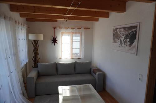a living room with a couch and a window at FeWo BergZeit auf 1000 m Höhe mit Balkon, Parkplatz, WLAN, Küche in Wertach