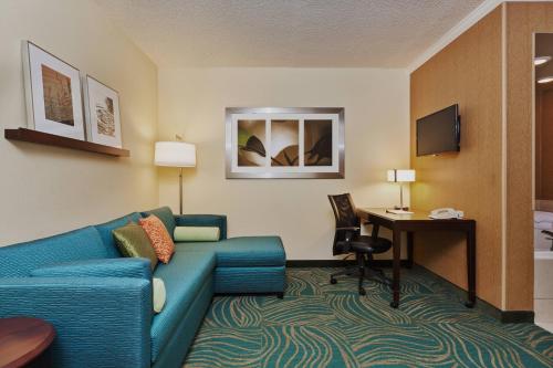 a living room with a couch and a desk in a hotel room at SpringHill Suites Charlotte Lake Norman/Mooresville in Mooresville