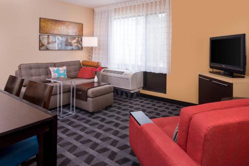 a living room with a couch and a tv at TownePlace Suites Huntington in Huntington