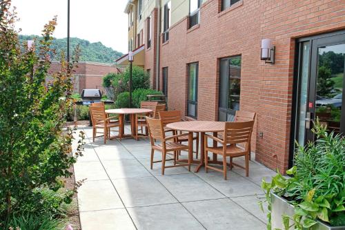 a patio with tables and chairs next to a brick building at TownePlace Suites Huntington in Huntington