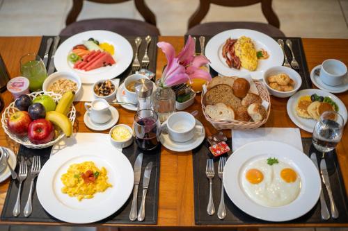 a table with plates of breakfast food on it at Crowne Plaza Asunción by IHG in Asuncion