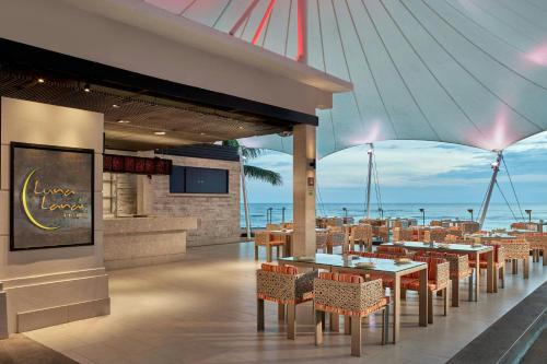 a restaurant with tables and chairs and the ocean at Sheraton Hua Hin Resort & Spa in Cha Am