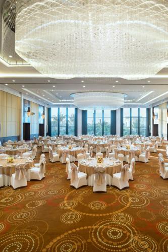 a large banquet hall with white tables and chairs at Sheraton Hua Hin Resort & Spa in Cha Am
