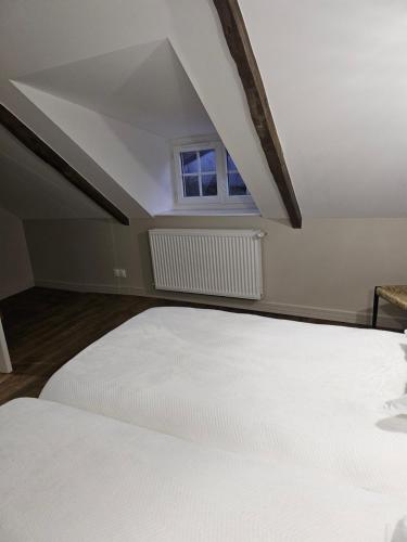 a bedroom with a white bed and a window at Moulin de Kerstrat in Brennilis