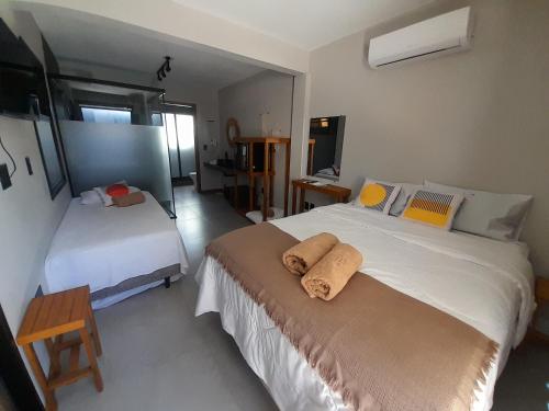 a bedroom with two beds with towels on it at Pousada Kirana in Praia do Rosa