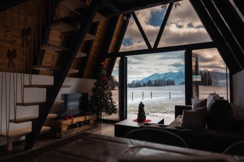 a living room with a christmas tree and a large window at Golden Valley Brezna in Pluzine