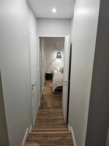 a hallway leading to a bedroom with a bed at Moulin de Kerstrat in Brennilis