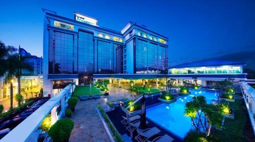 un grande edificio con piscina di fronte di Grand Hotel Preanger a Bandung