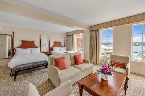 a hotel room with a bed and a living room at Hamilton Princess & Beach Club A Fairmont Managed Hotel in Hamilton