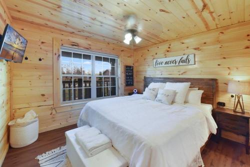 a bedroom with a large bed in a log cabin at Enchanted Forest Cabin And Teepee! Lights & Laser Show! Private Hot Tub! Unique Stay! in Sevierville