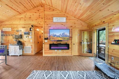 a living room with a tv in a wooden wall at Enchanted Forest Cabin And Teepee! Lights & Laser Show! Private Hot Tub! Unique Stay! in Sevierville