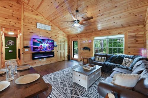 a living room with a couch and a tv at Enchanted Forest Cabin And Teepee! Lights & Laser Show! Private Hot Tub! Unique Stay! in Sevierville