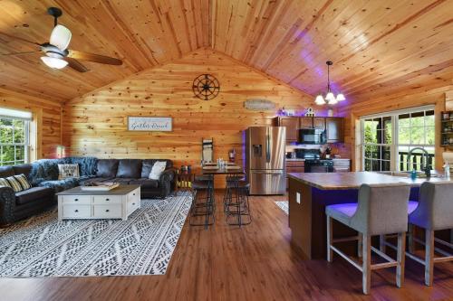 a living room with a couch and a kitchen at Enchanted Forest Cabin And Teepee! Lights & Laser Show! Private Hot Tub! Unique Stay! in Sevierville