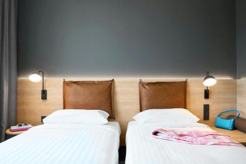 two beds sitting next to each other in a room at Moxy Bristol in Bristol