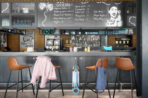 a bar with orange chairs and a chalkboard at Moxy Bristol in Bristol
