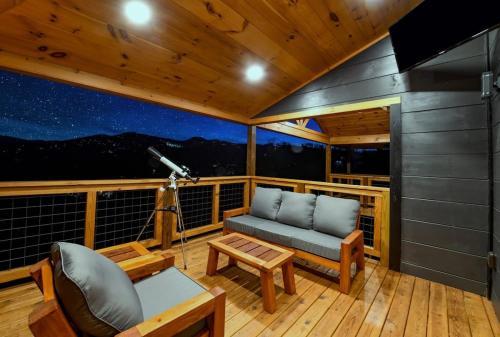 a room with a couch and a table on a balcony at Big Bear Shack - Handicap Accessible & Dog Friendly in Gatlinburg