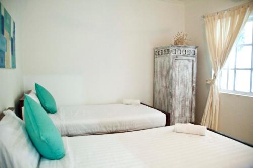 a room with two beds and a window at The Beach House in Kep