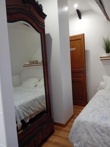 a bedroom with a mirror next to a bed at Le Moulin des Roses in Neslette