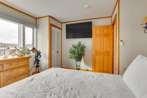 a bedroom with a bed and a window and a television at Waterfront Home on White Lake Near Bethel Woods! in White Lake