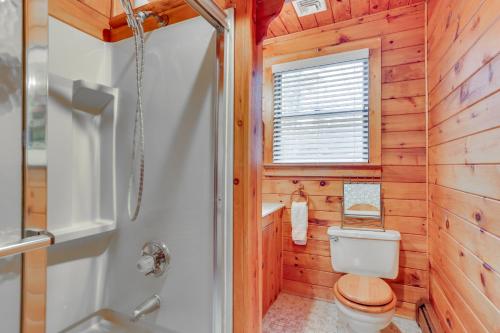 a wooden bathroom with a toilet and a window at Waterfront Home on White Lake Near Bethel Woods! in White Lake
