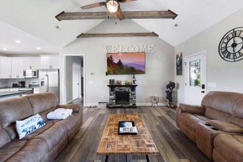 a living room with two brown couches and a fireplace at H2Oasis Incredible Pool Retreat With Mountains Views! in Sevierville