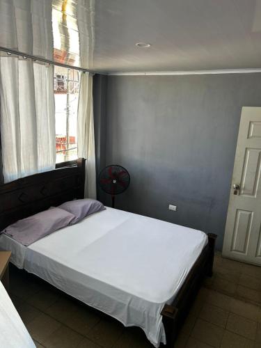 a bedroom with a white bed with a window at Hotel Rio Puntarenas in Puntarenas