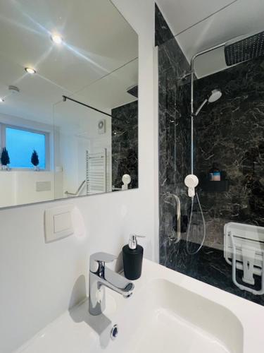 a white bathroom with a sink and a shower at Cosy in Mechelen