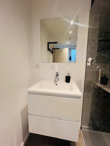 a white bathroom with a sink and a mirror at Cosy in Mechelen
