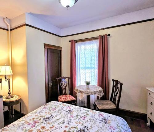 a bedroom with a bed and a table and a window at Royal Hotel Sydney in Sydney