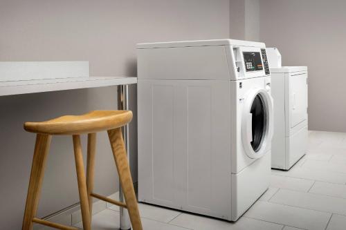 a white washing machine next to a counter and a stool at SpringHill Suites by Marriott Atlanta Perimeter Center in Atlanta