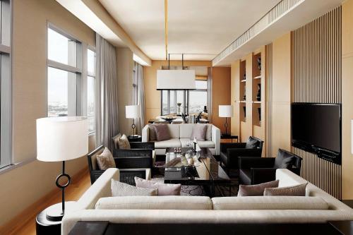 a living room with a white couch and chairs at Bangkok Marriott Hotel Sukhumvit in Bangkok