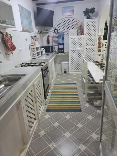 a kitchen with white counters and a sink at Nyumba Tulivu in Watamu