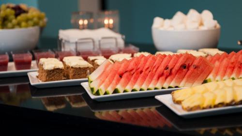 a bunch of different types of desserts on plates on a table at Thon Hotel Nordlys in Bodø