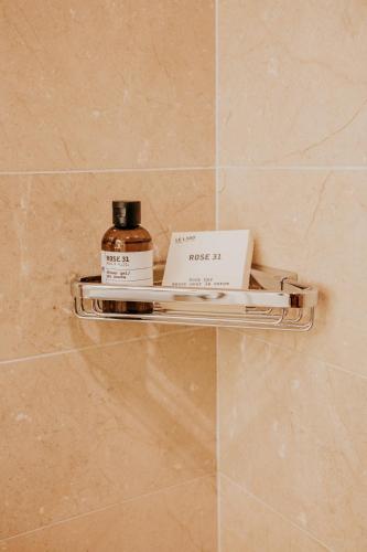 a shelf in a bathroom with a bottle and a book at Hamilton Princess & Beach Club A Fairmont Managed Hotel in Hamilton