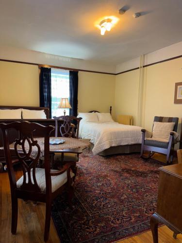 a bedroom with a bed and a table and a chair at Royal Hotel Sydney in Sydney