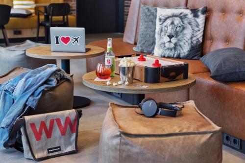 a room with couches and a table with a lion pillow at Moxy Frankfurt Airport Kelsterbach in Kelsterbach