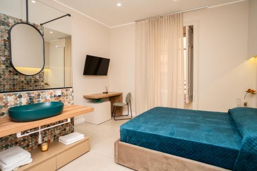 a bedroom with a blue bed and a sink at Amnis rooms in Salerno
