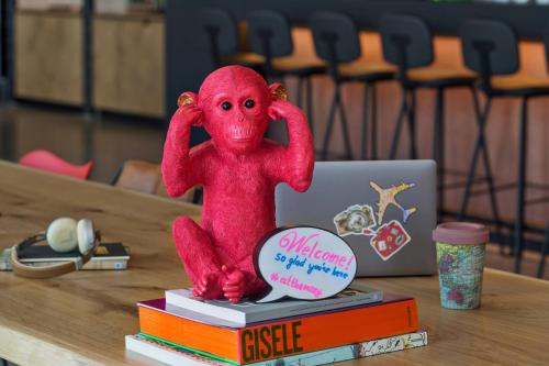 a small red figurine sitting on top of books at Moxy Frankfurt Airport Kelsterbach in Kelsterbach
