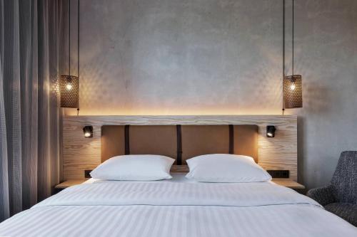 a bedroom with a large bed with two white pillows at Moxy Frankfurt Airport Kelsterbach in Kelsterbach