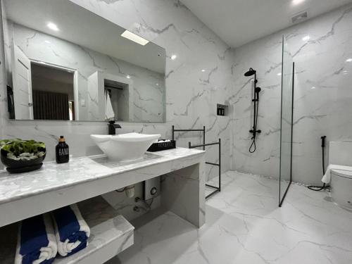 a white bathroom with a sink and a shower at Pineale Villas, Resort and Spa in Panglao