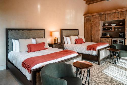 a bedroom with two beds and a chair at Hábimo - Valle de Guadalupe in Valle de Guadalupe