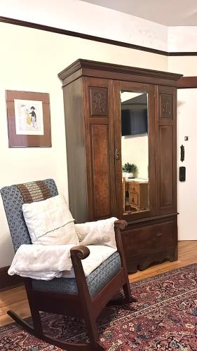 a chair in a living room with a cabinet at Royal Hotel Sydney in Sydney