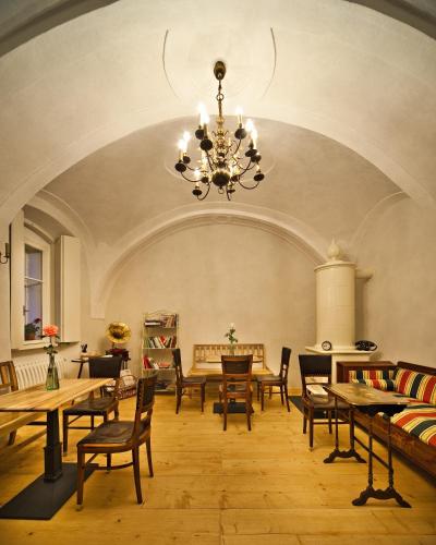 a large room with tables and chairs and a chandelier at Café FARA in Klentnice