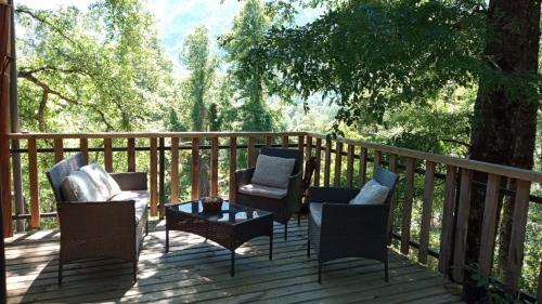a deck with chairs and a coffee table on it at Cabaña en Parcela con Tinaja in Trancura