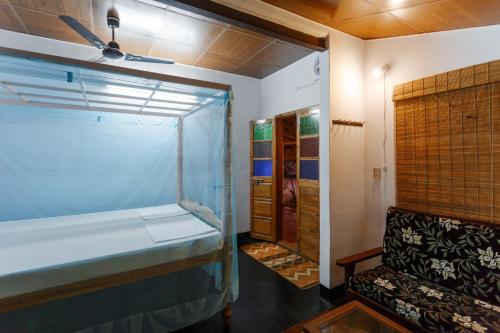 a small room with a bed and a window at Sea Hut Homestay in Cochin